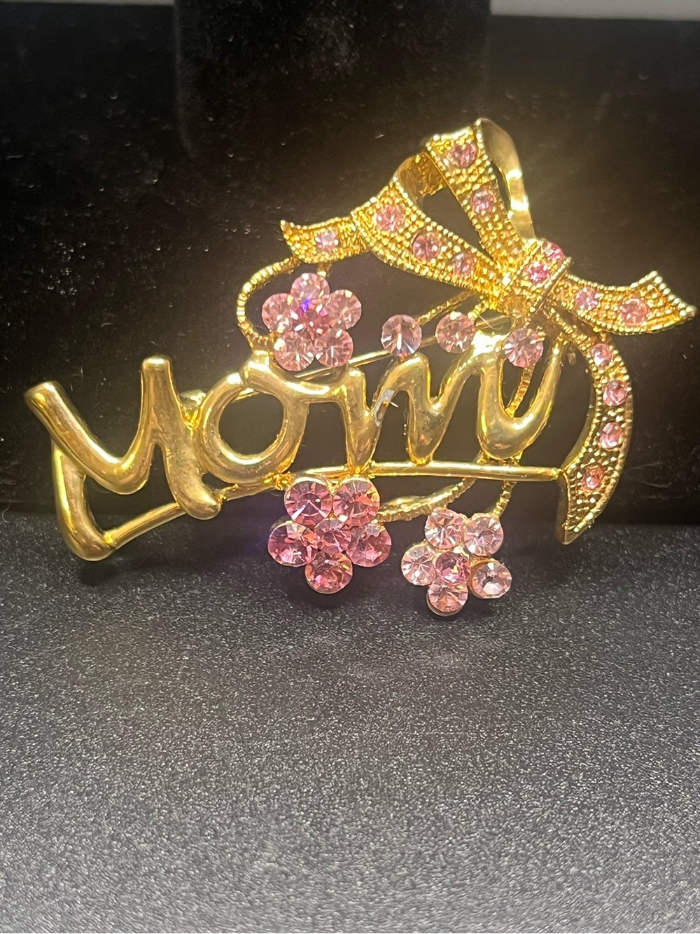 Pretty gold-tone “Mom” brooch accented with sparkling pink rhinestones.